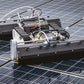Angled close-up of the M1 robot focusing on its brush assembly and compact body as it moves across solar panels