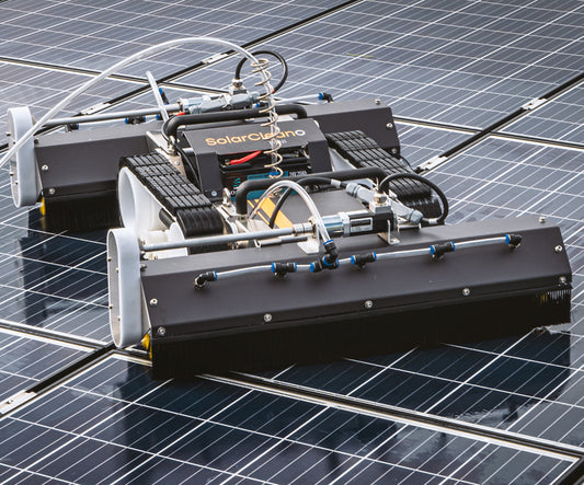 Angled close-up of the M1 robot focusing on its brush assembly and compact body as it moves across solar panels