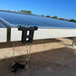 Dark gray solar clip attached to a solar panel with water droplets falling from it.