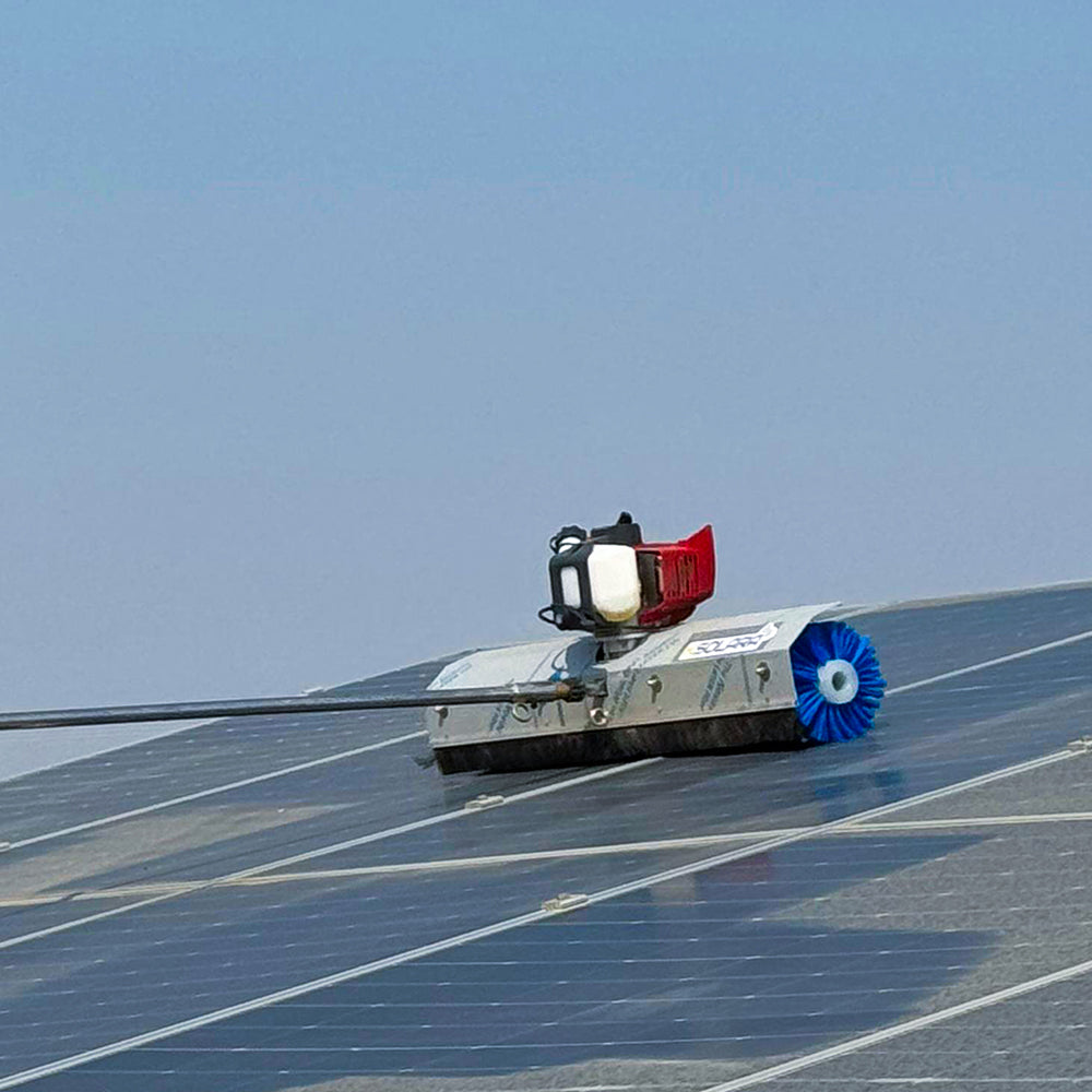 A solar panel cleaning robot with a red and silver body and blue brushes, moving along a solar panel.