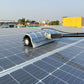 An electric rotating solar cleaning brush with a silver brush head and black handle being used on a solar panel.