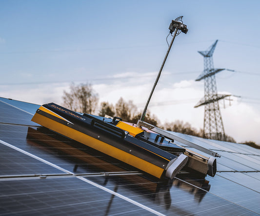 PVCARE F1 solar panel cleaning robot in action, actively cleaning solar panels with rotating brushes