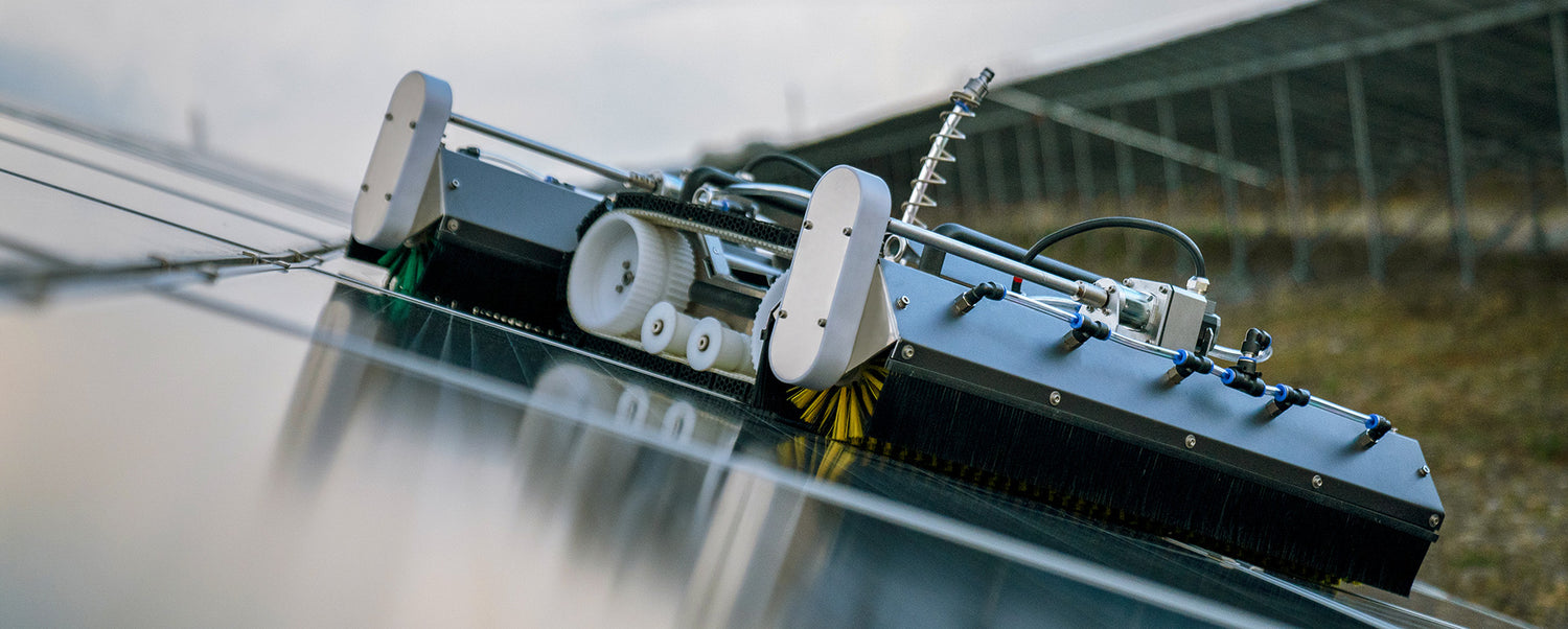 Diagonal view of the PVCARE M1 mini solar panel cleaning robot with caterpillar tracks and brush assembly positioned on solar panels