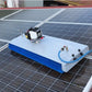 A solar panel cleaning machine mounted on a roof, with blue hoses and machinery visible against the solar panels.