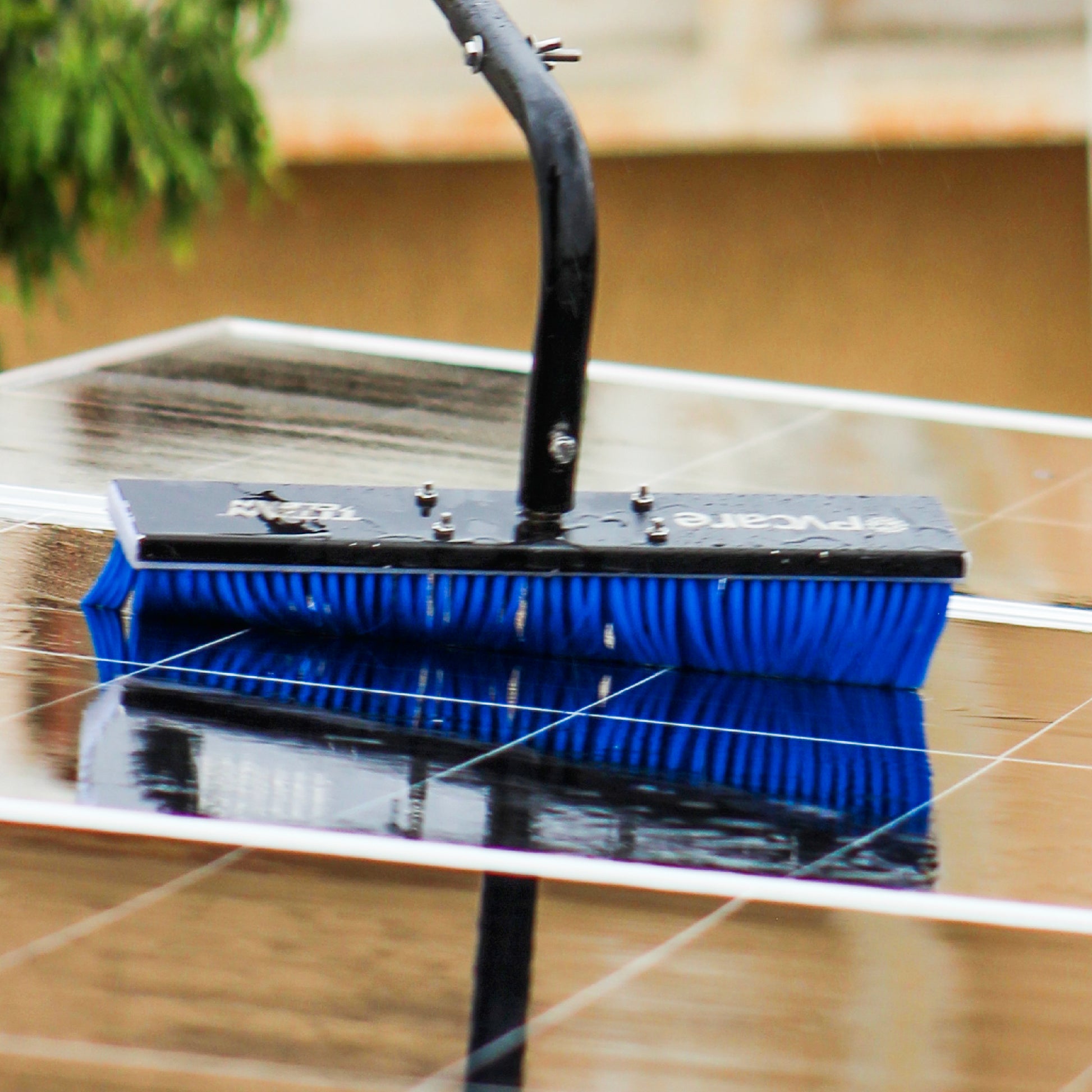 Solar Cleaning tool with blue bristles on a reflective surface
