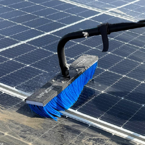 Solar cleaning brush with blue bristles cleaning a solar panel